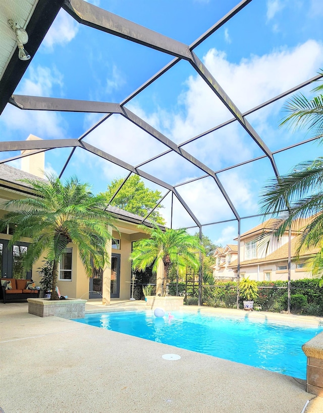 view of swimming pool featuring a patio area and a lanai