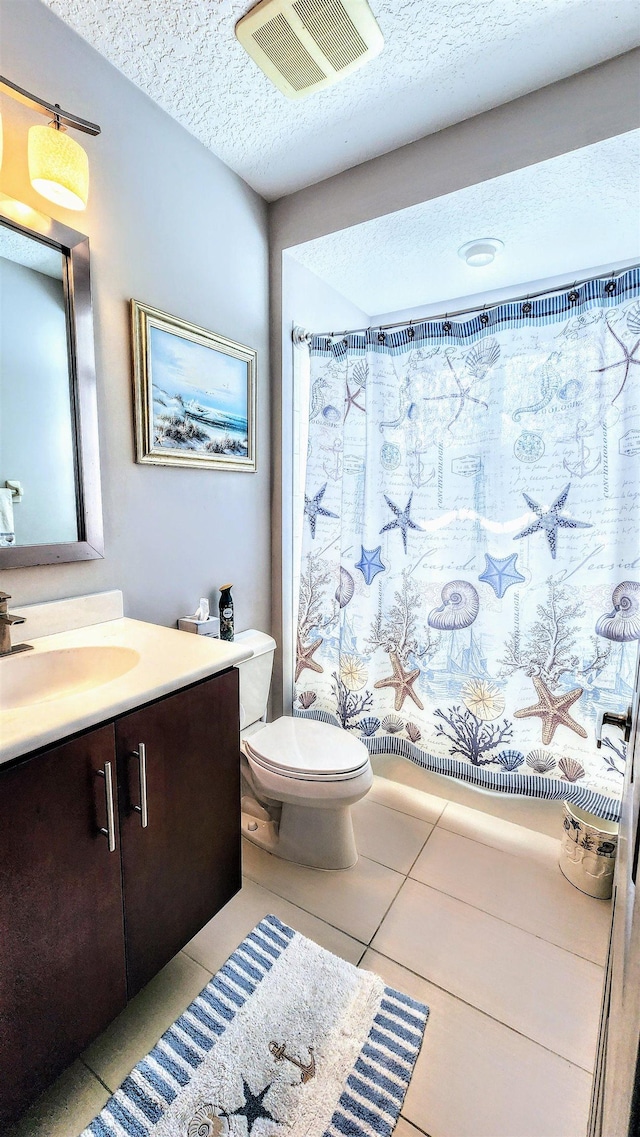 bathroom featuring tile patterned floors, vanity, a textured ceiling, and toilet