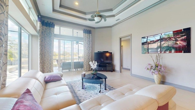 living room with a tray ceiling, crown molding, and a towering ceiling