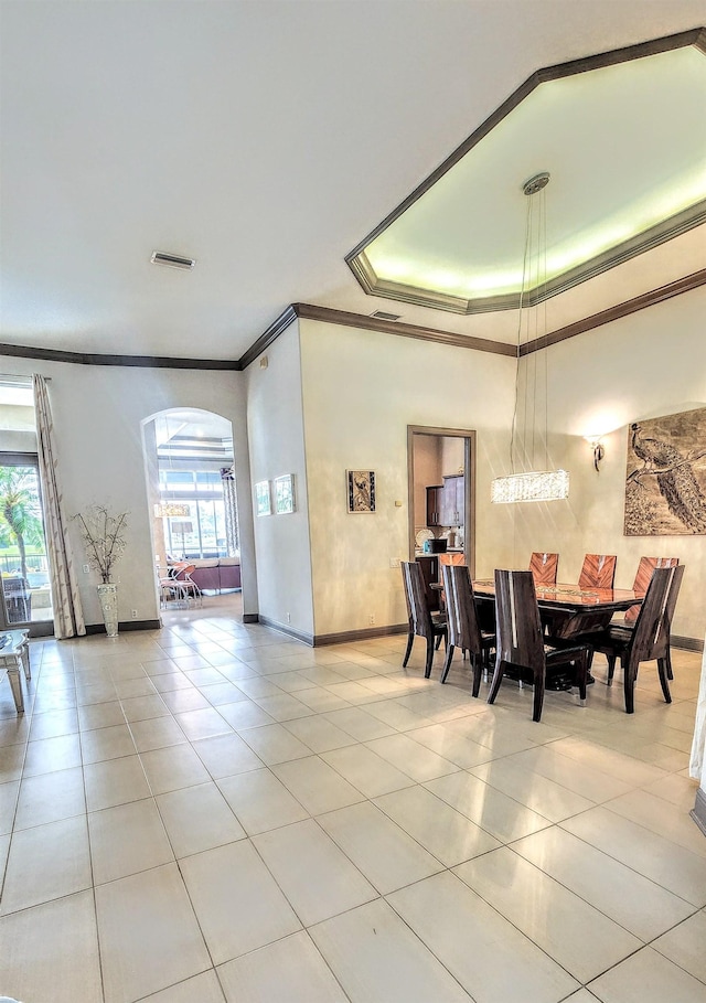 tiled dining area featuring crown molding