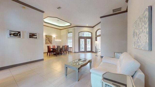 tiled living room with crown molding and french doors