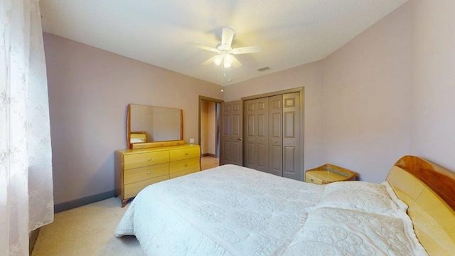 carpeted bedroom featuring ceiling fan and a closet