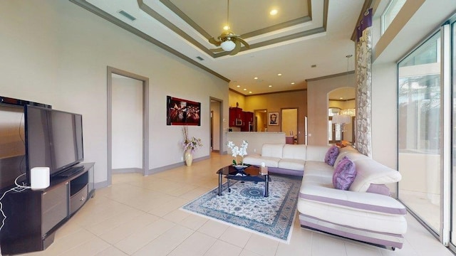 living room featuring ornamental molding, a raised ceiling, and light tile patterned floors