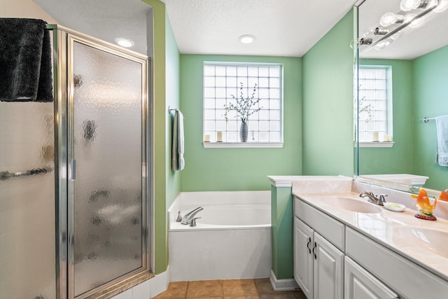 bathroom featuring plus walk in shower, a textured ceiling, vanity, and tile patterned floors