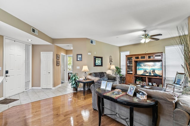 living room with ceiling fan and light hardwood / wood-style flooring