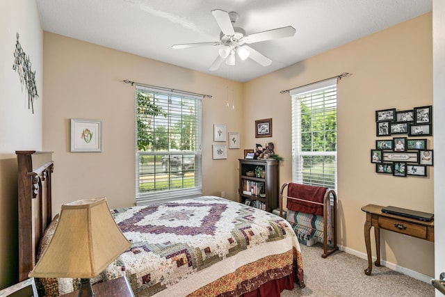 carpeted bedroom with multiple windows and ceiling fan