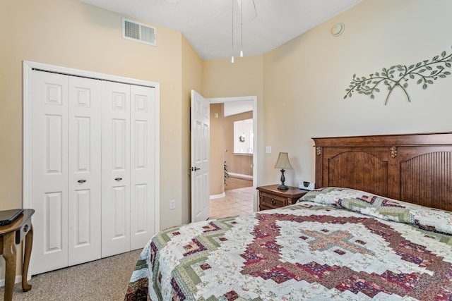 carpeted bedroom with ceiling fan and a closet