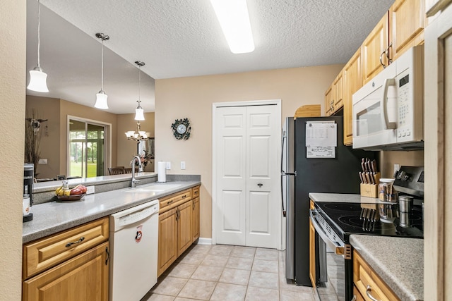 kitchen with a textured ceiling, white appliances, sink, decorative light fixtures, and an inviting chandelier