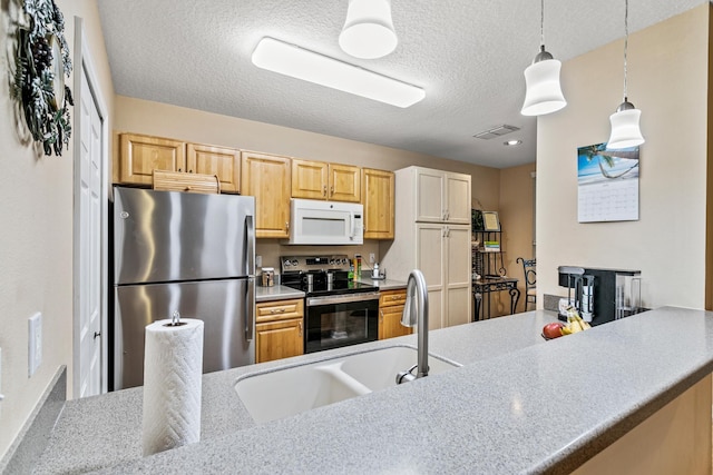 kitchen with sink, light brown cabinets, a textured ceiling, decorative light fixtures, and appliances with stainless steel finishes