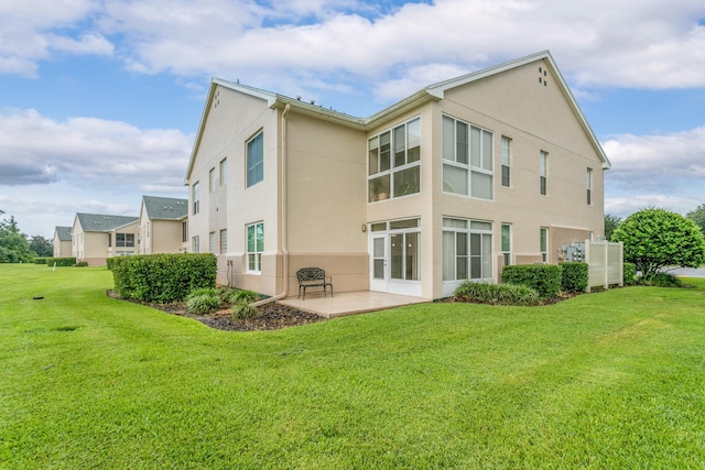 rear view of property with a yard and a patio