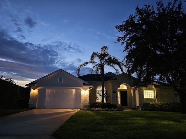 ranch-style home featuring a garage and a yard