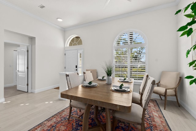 dining room with light wood-type flooring and ornamental molding