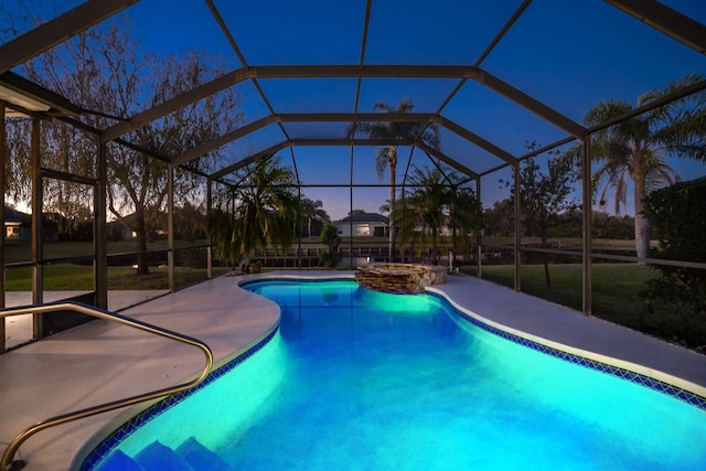 pool at dusk featuring glass enclosure, an in ground hot tub, and a patio