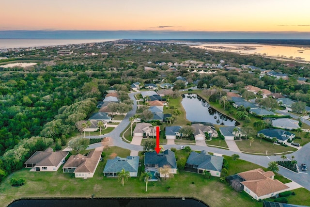 aerial view at dusk featuring a water view