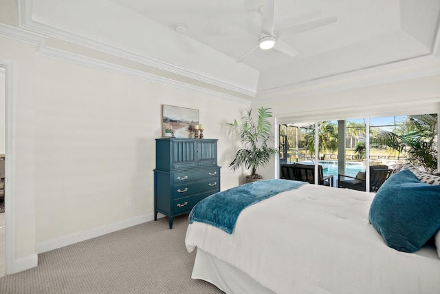 carpeted bedroom featuring ceiling fan, access to exterior, crown molding, and a tray ceiling