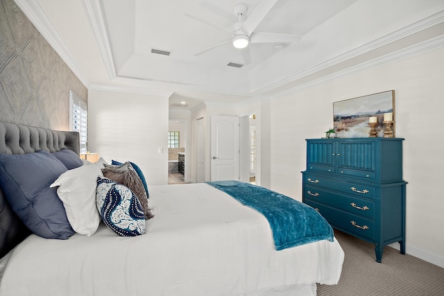 bedroom with a raised ceiling, ornamental molding, light colored carpet, ceiling fan, and connected bathroom