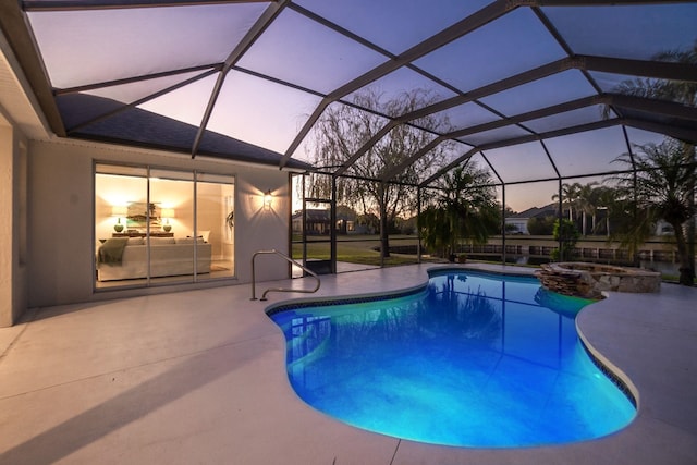 pool at dusk featuring a patio and a lanai