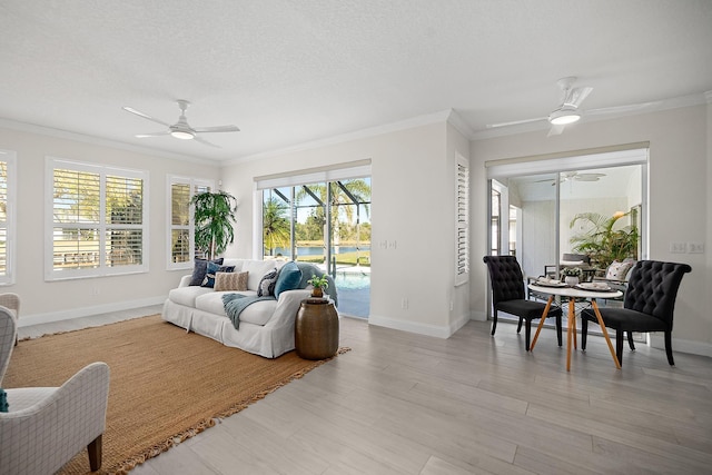 living room featuring a textured ceiling, light hardwood / wood-style flooring, ceiling fan, and ornamental molding