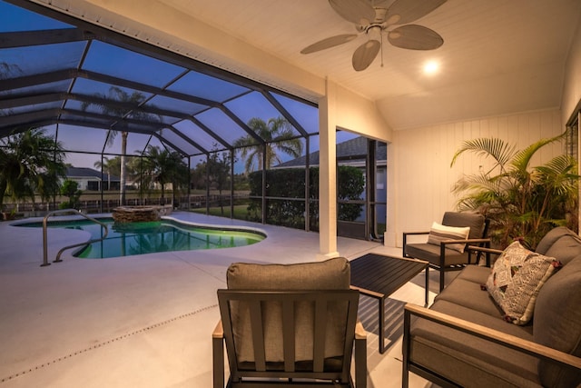 pool at dusk with glass enclosure, ceiling fan, an in ground hot tub, outdoor lounge area, and a patio area