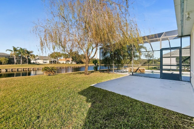 view of yard with glass enclosure, a water view, and a patio