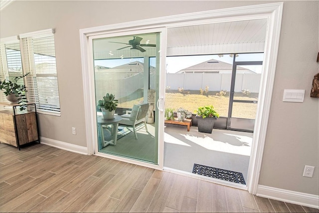 doorway with ceiling fan and a healthy amount of sunlight