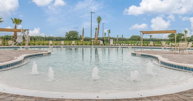 view of swimming pool with pool water feature and a patio area