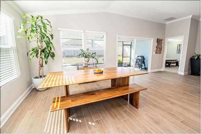 dining area featuring light hardwood / wood-style flooring, crown molding, and lofted ceiling