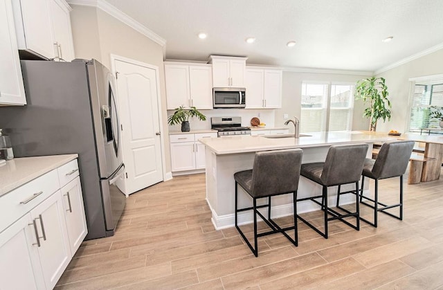 kitchen featuring sink, white cabinets, a kitchen island with sink, and appliances with stainless steel finishes