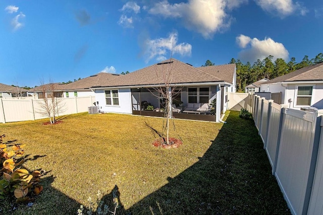 rear view of house featuring a yard and central AC unit