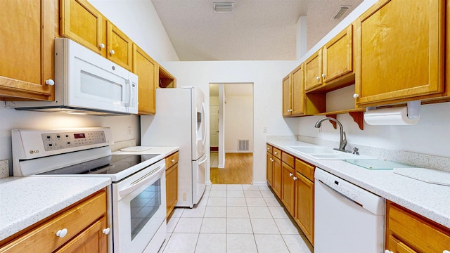 kitchen featuring white appliances, light tile patterned floors, visible vents, and a sink