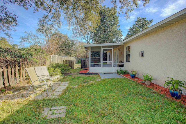 view of yard with a patio area, fence, and a sunroom