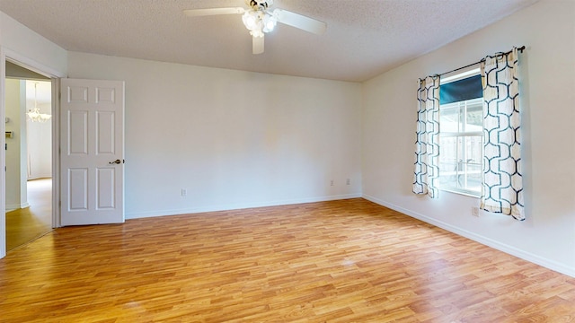 spare room featuring baseboards, ceiling fan, a textured ceiling, and light wood finished floors