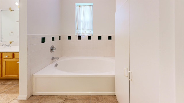 bathroom with tile patterned flooring, a garden tub, and vanity