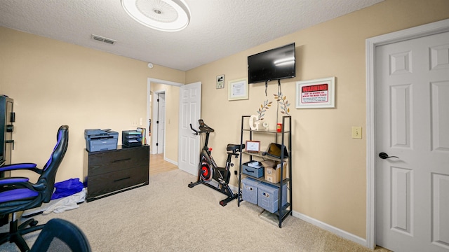 carpeted home office with a textured ceiling