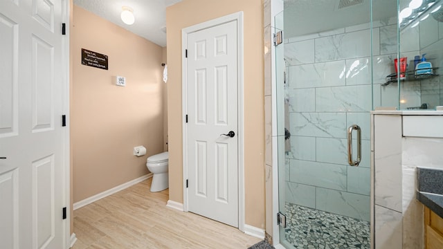 bathroom with vanity, a shower with shower door, a textured ceiling, and toilet