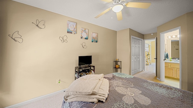 carpeted bedroom featuring a textured ceiling, ensuite bathroom, a closet, and ceiling fan