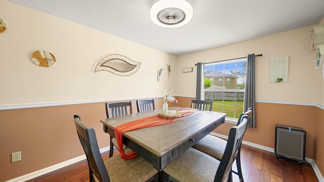 dining space featuring dark hardwood / wood-style flooring and a textured ceiling