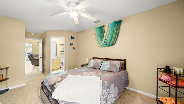 carpeted bedroom with ensuite bath and ceiling fan