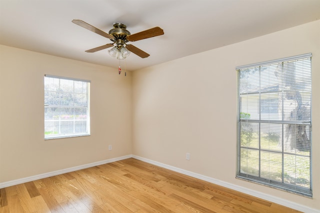 empty room featuring baseboards, a ceiling fan, and light wood finished floors