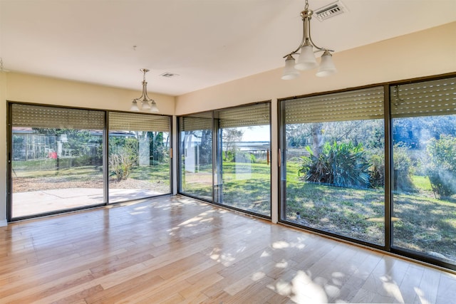 unfurnished sunroom with an inviting chandelier and visible vents