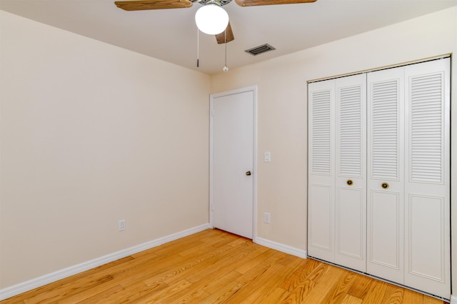 unfurnished bedroom featuring a closet, visible vents, light wood-style flooring, and baseboards