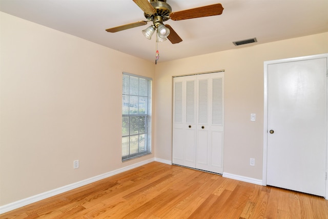 unfurnished bedroom featuring visible vents, baseboards, light wood-style floors, a closet, and a ceiling fan