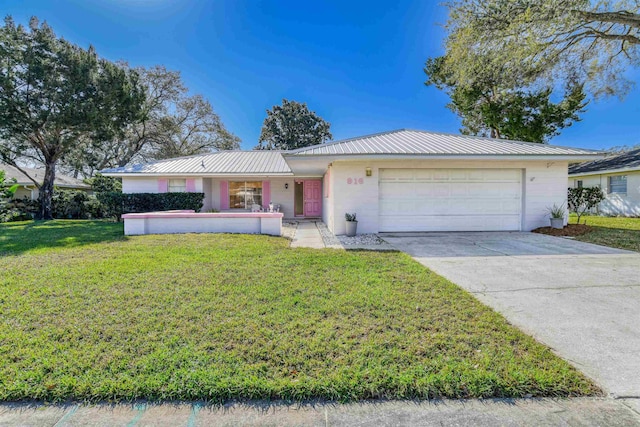 ranch-style house featuring a front yard, an attached garage, stucco siding, concrete driveway, and metal roof