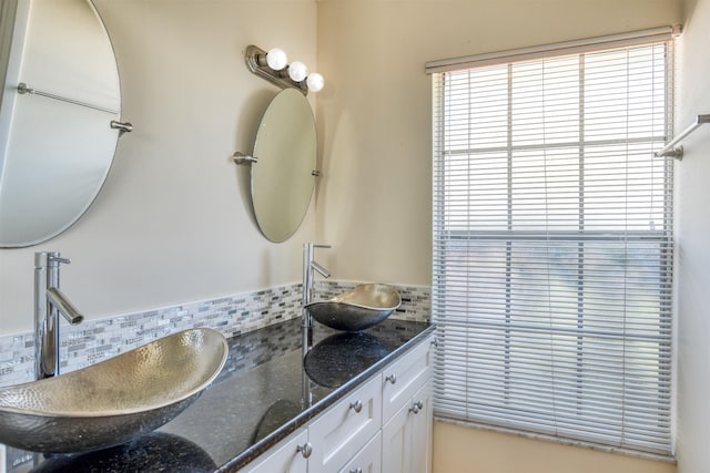 full bathroom featuring decorative backsplash, double vanity, and a sink