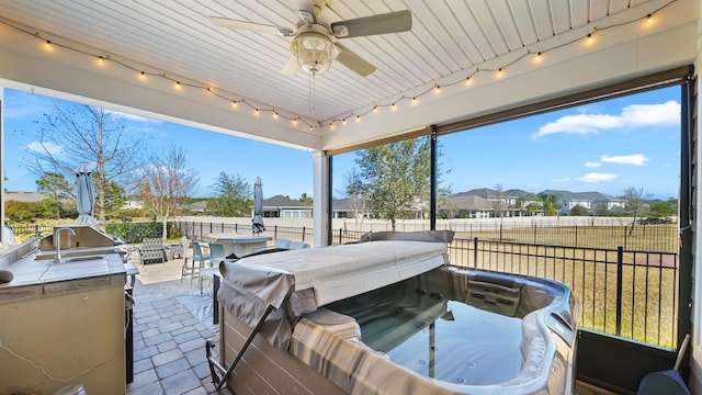 view of patio / terrace featuring a ceiling fan, area for grilling, a fenced backyard, a hot tub, and a residential view