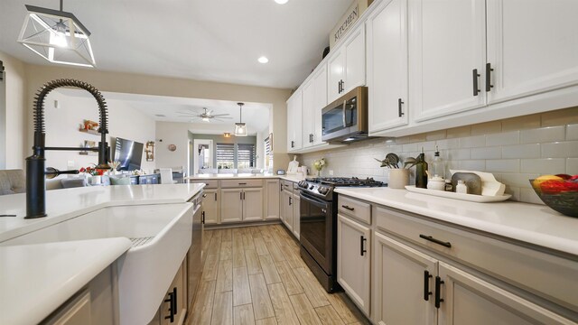 kitchen with hanging light fixtures, backsplash, appliances with stainless steel finishes, and a sink