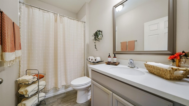 bathroom featuring toilet, vanity, and wood finished floors
