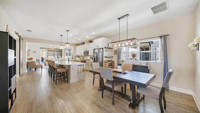 dining area featuring light wood-style flooring, recessed lighting, baseboards, and visible vents