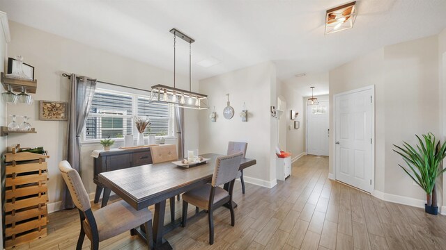 dining area featuring baseboards and light wood-style flooring