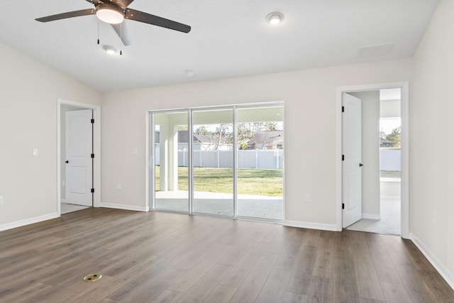 empty room featuring wood finished floors, a ceiling fan, and baseboards